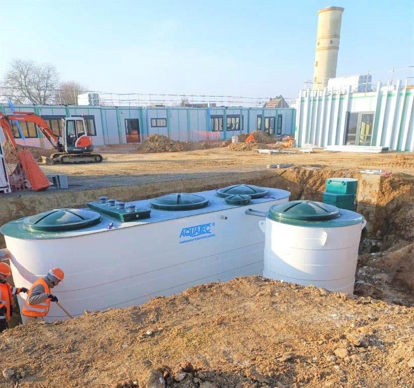 Station de traitement des eaux usées conteneurisée en cours d'installation, avec techniciens sur site