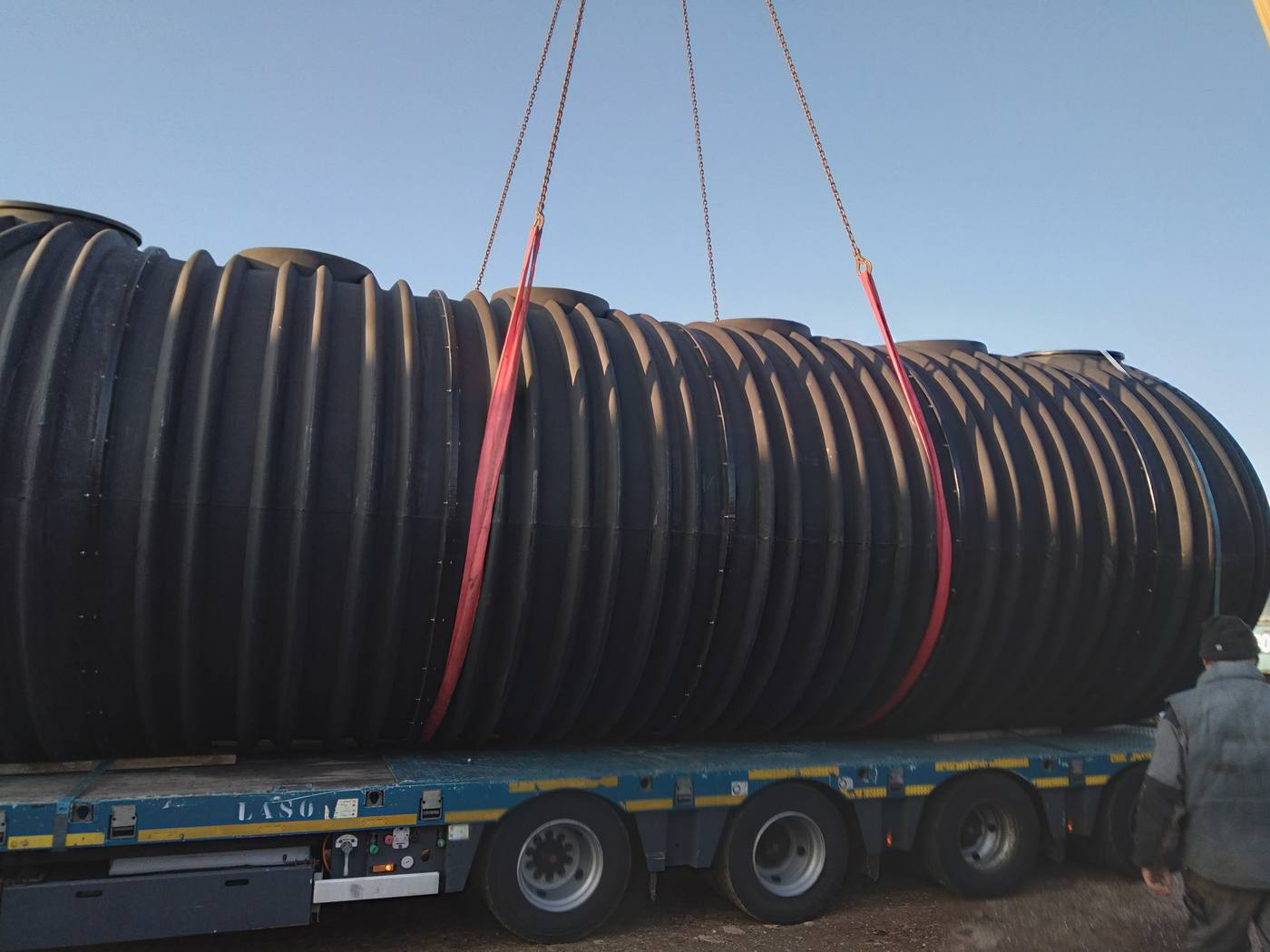 Cuve industrielle de grand volume en cours de grutage sur site